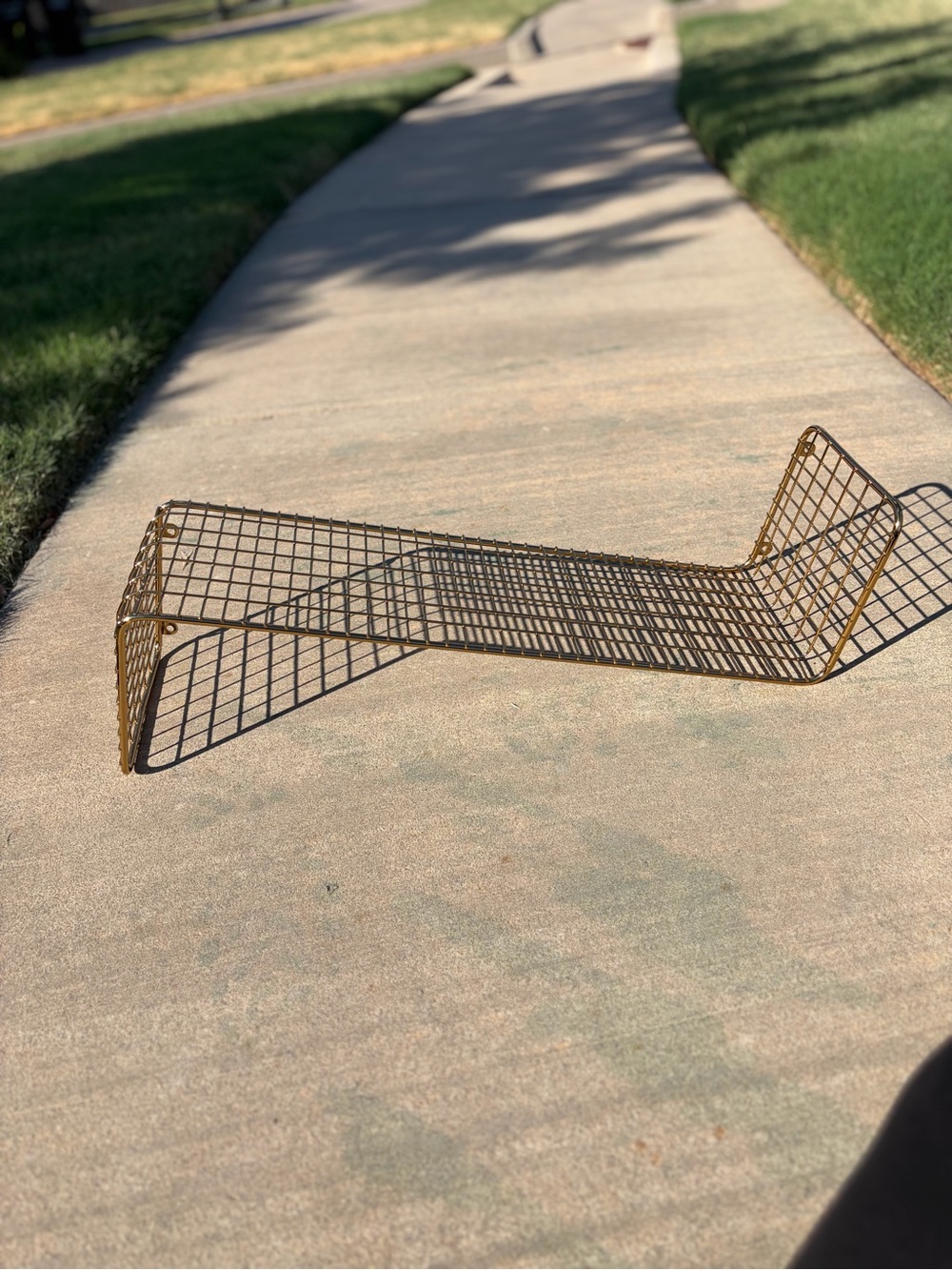 IKEA Svenshult gold-finished wire mesh wall shelf.